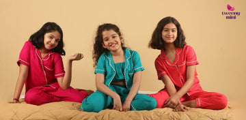 Three girls in colorful night suits sitting on a bed, kids sleepwear, comfortable pajamas