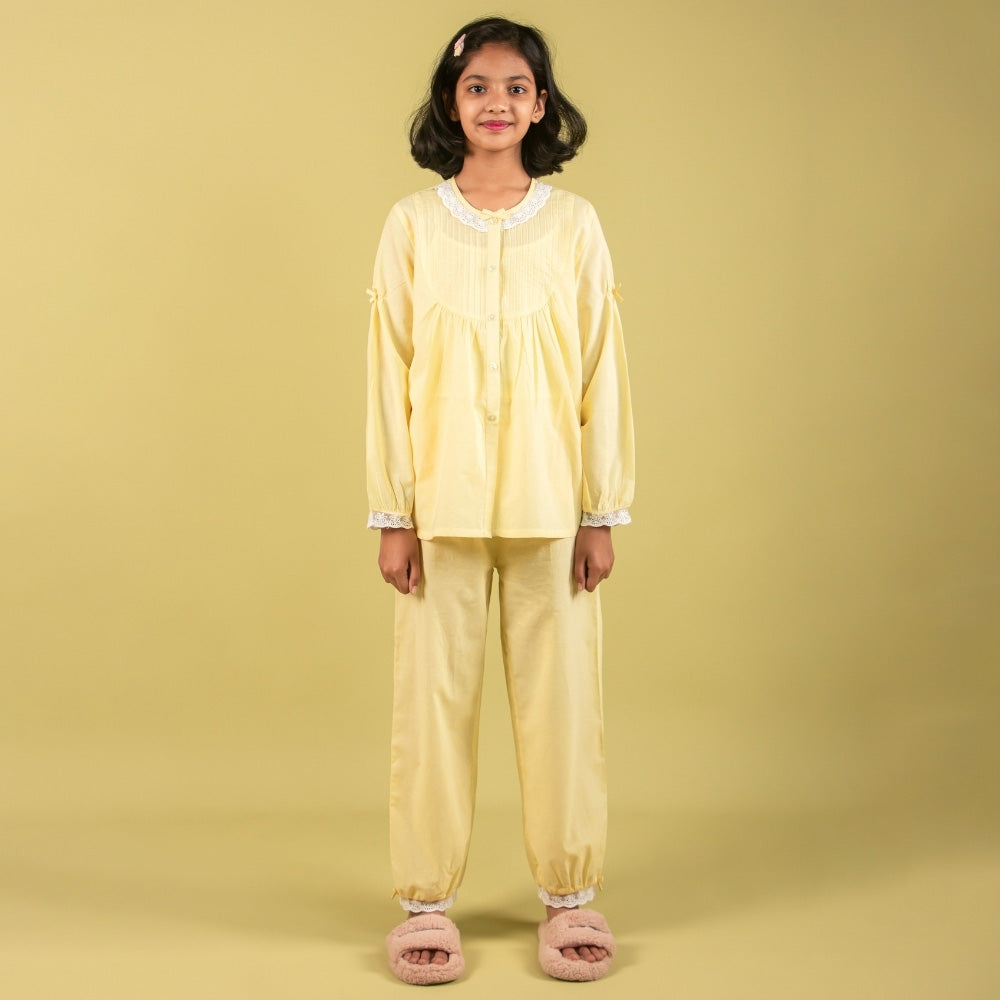 Girl wearing yellow night suit with lace details and slippers, kids nightwear fashion