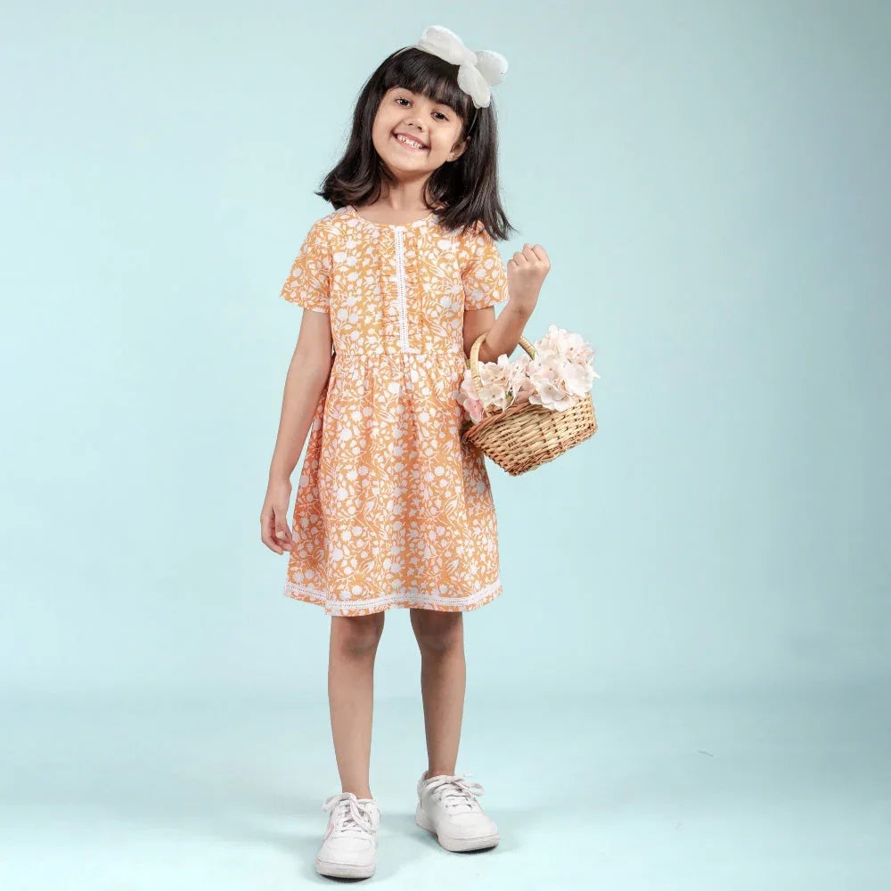 Smiling girl in an orange floral dress holding a flower basket, kids summer dress fashion