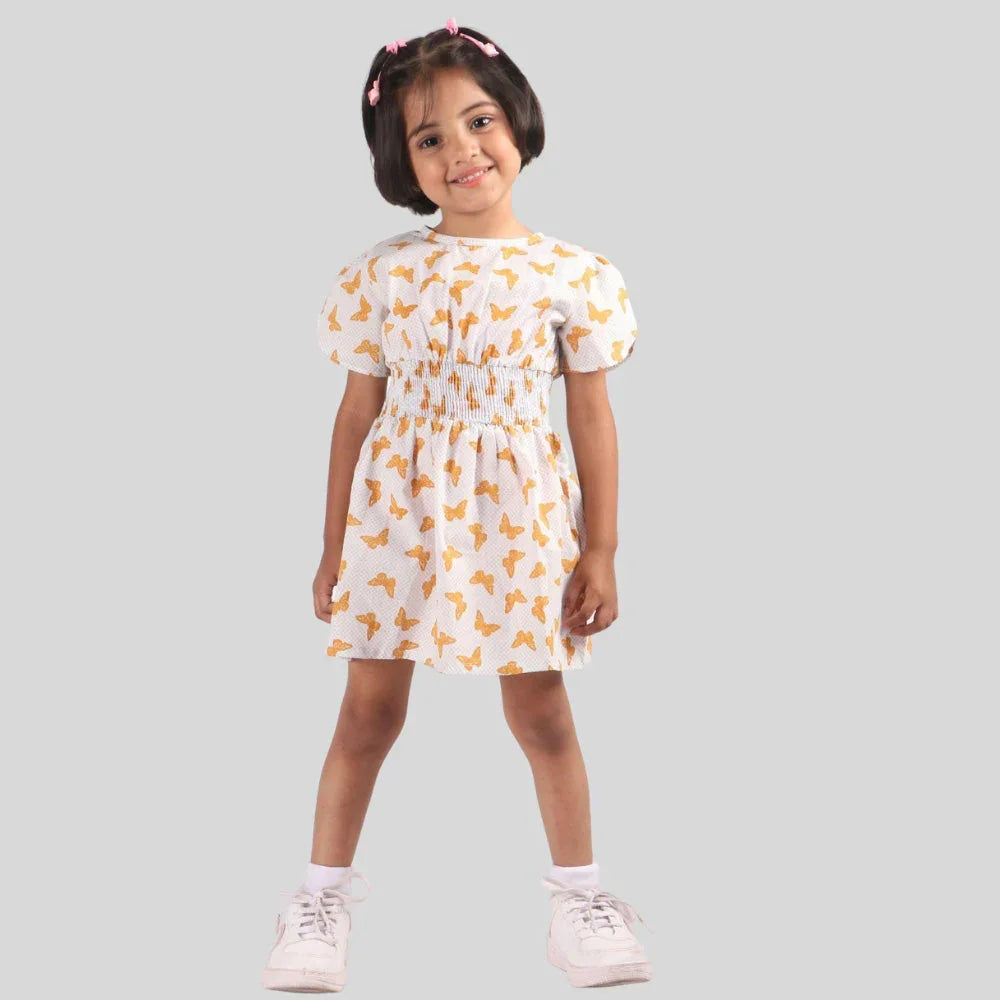 Smiling young girl in white butterfly print dress and sneakers, kids summer fashion outfit