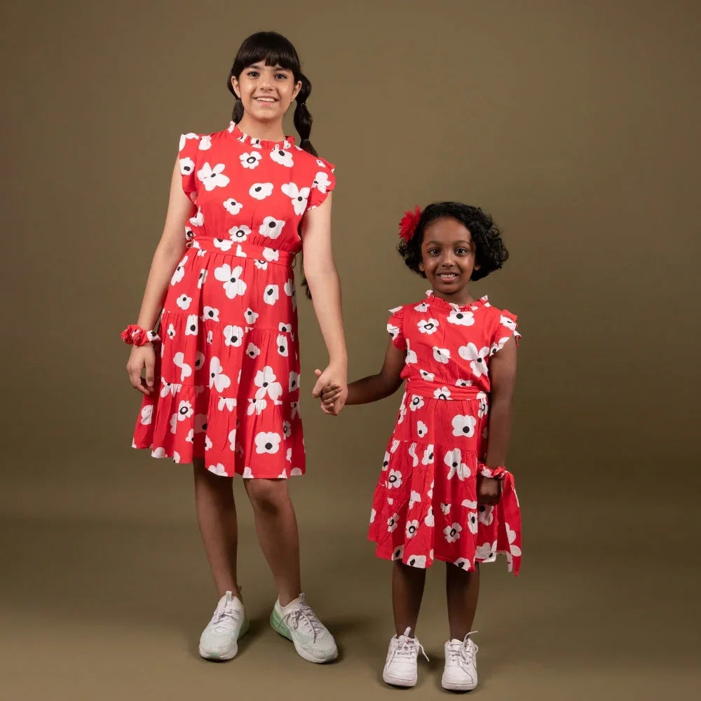 Two girls in matching red floral dresses holding hands, stylish kids wear fashion
