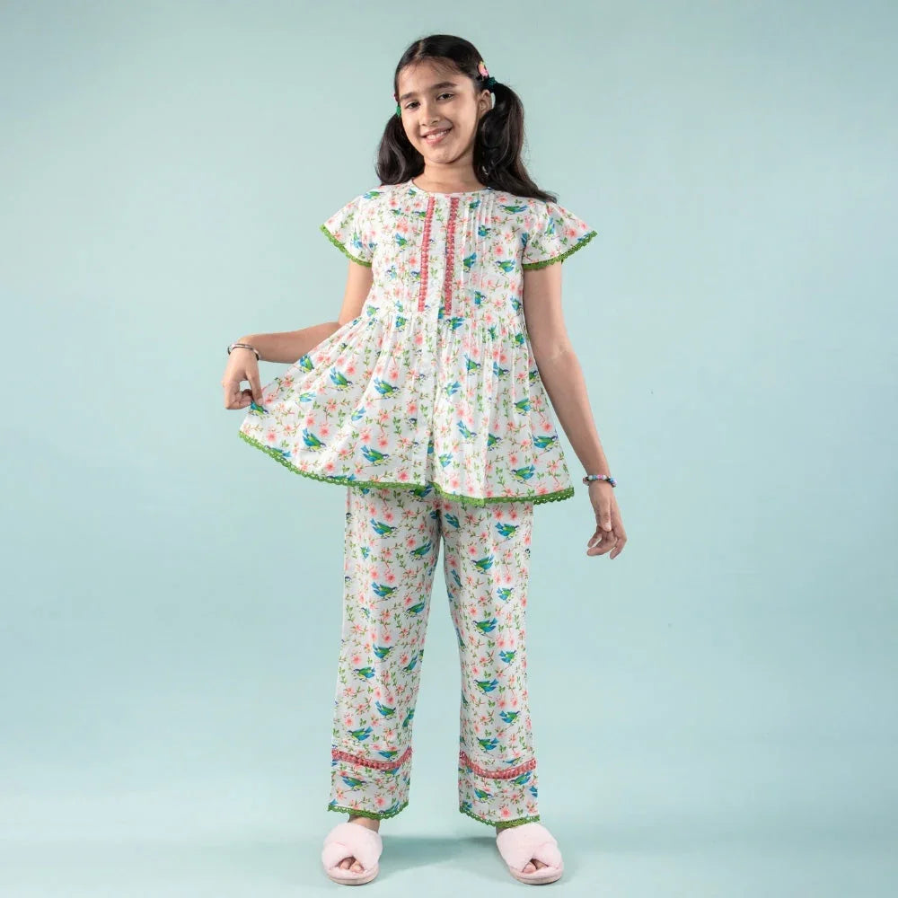 Girl wearing floral printed night suit with short-sleeve top and matching pants
