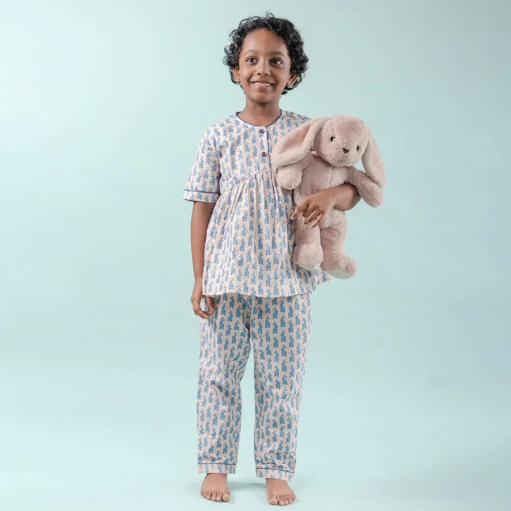Girl in printed cotton night suit holding plush bunny, kids sleepwear fashion outfit