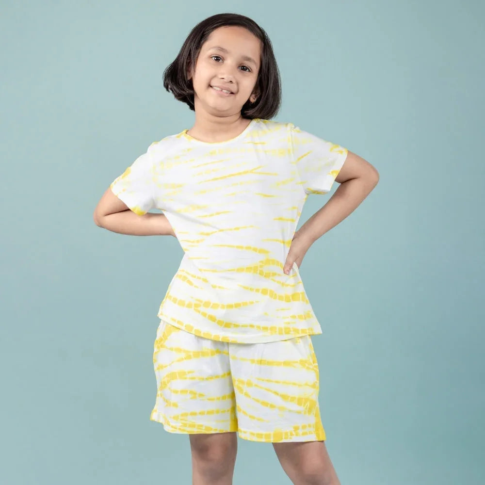 Girl wearing a yellow and white tie-dye nightdress set, short sleeves and shorts