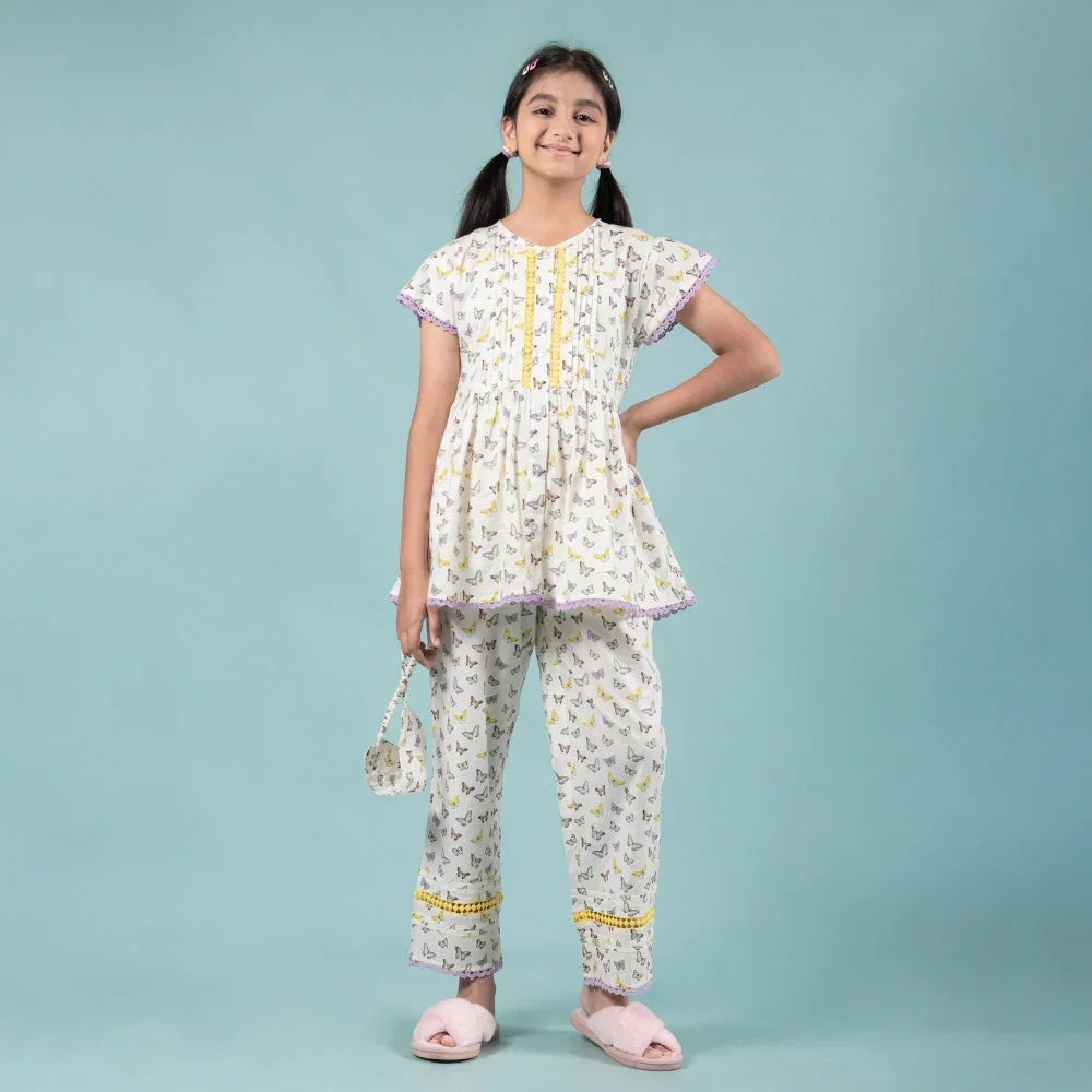 Girl in printed nightdress pajama set with butterfly pattern, holding pouch, on blue background