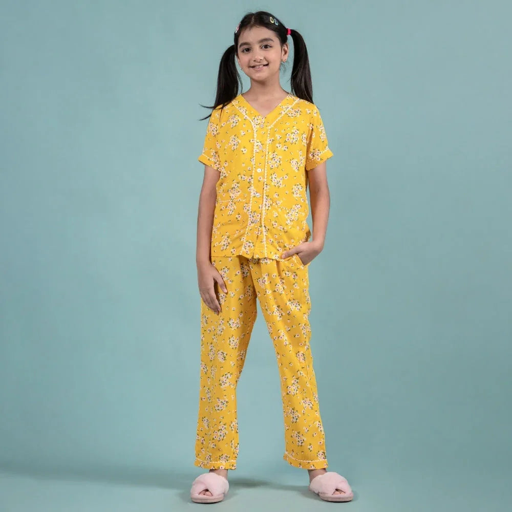 Girl wearing yellow floral nightwear set with short sleeves and matching pants