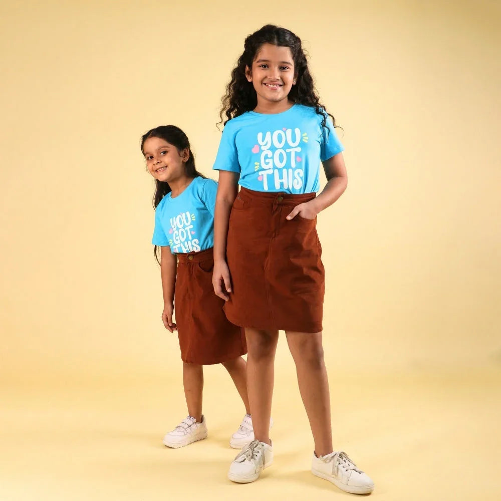 Girls wearing blue graphic t-shirts and brown skirts, kids fashion outfit for girls