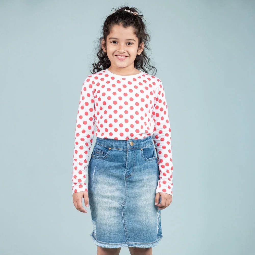 Girl in white and red polka dot long sleeve shirt and denim skirt, kids fashion outfit