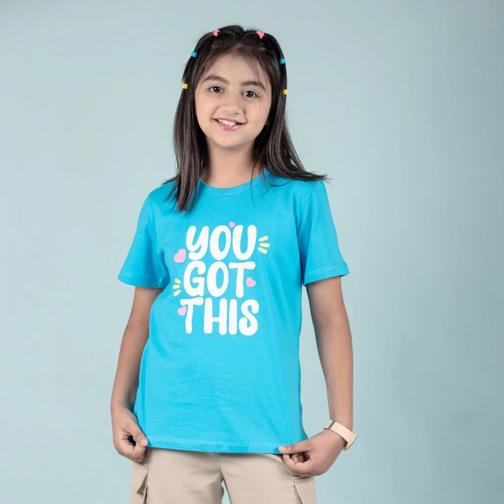 Smiling girl in blue graphic t-shirt with 'You Got This' text, kids casual wear