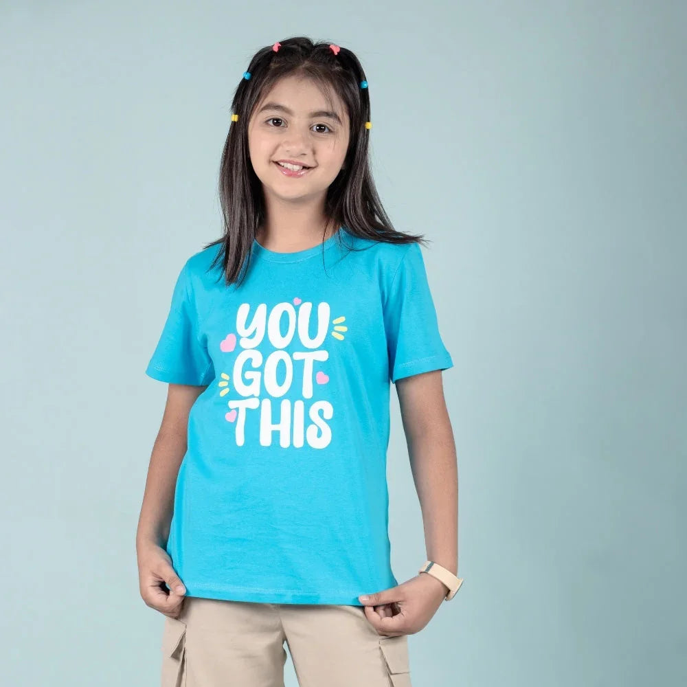 Girl wearing a blue graphic tee with 'You Got This' text, ideal for teens and casual outfits.