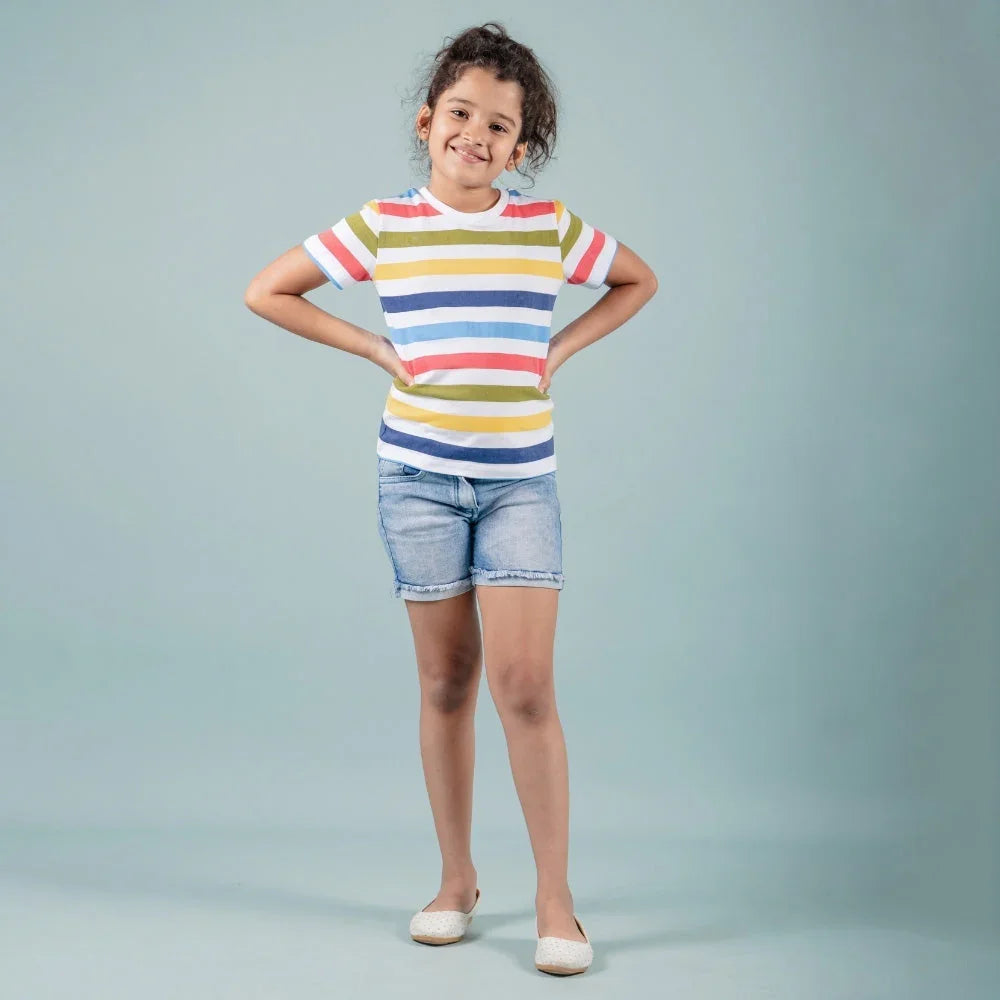 Girl wearing colorful striped t-shirt and denim shorts, casual kids fashion outfit