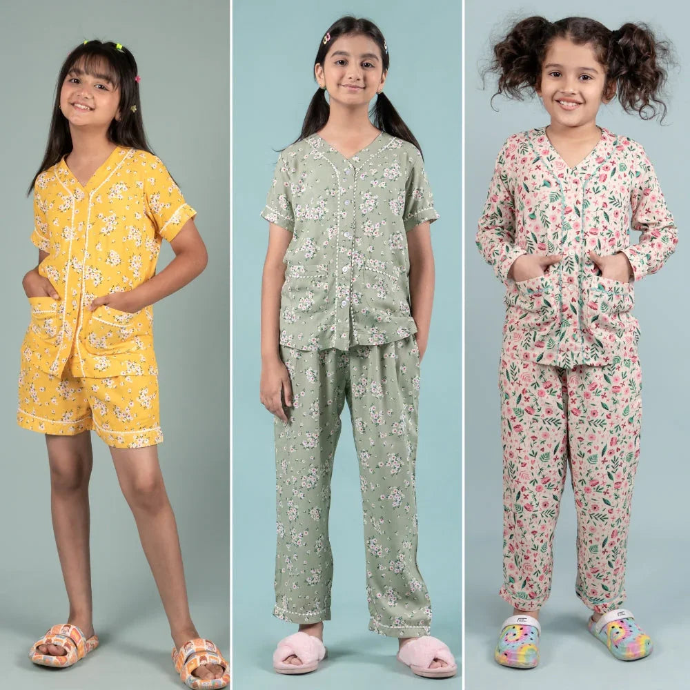 Three girls modeling premium floral night suits and pajamas for kids, pastel background